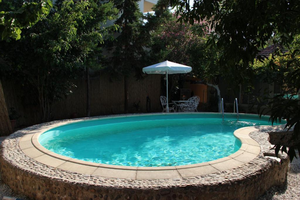 a swimming pool with an umbrella in a backyard at Seafalios Villa in Chania