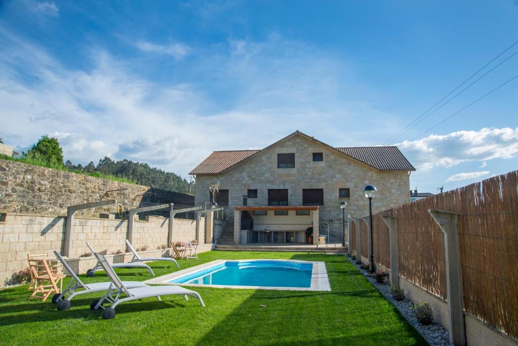 a backyard with a swimming pool and a house at Welcome Villa Briallos in Portas
