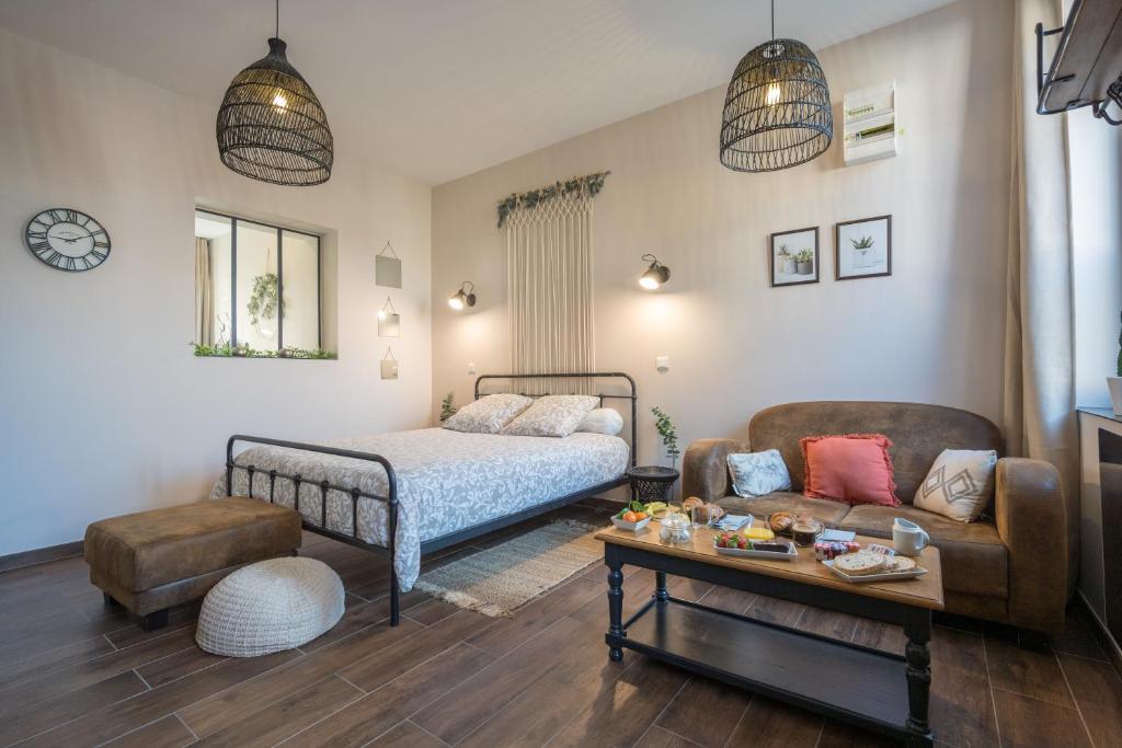 a bedroom with a bed and a couch and a table at 6 place de la détente in Saint-Venant