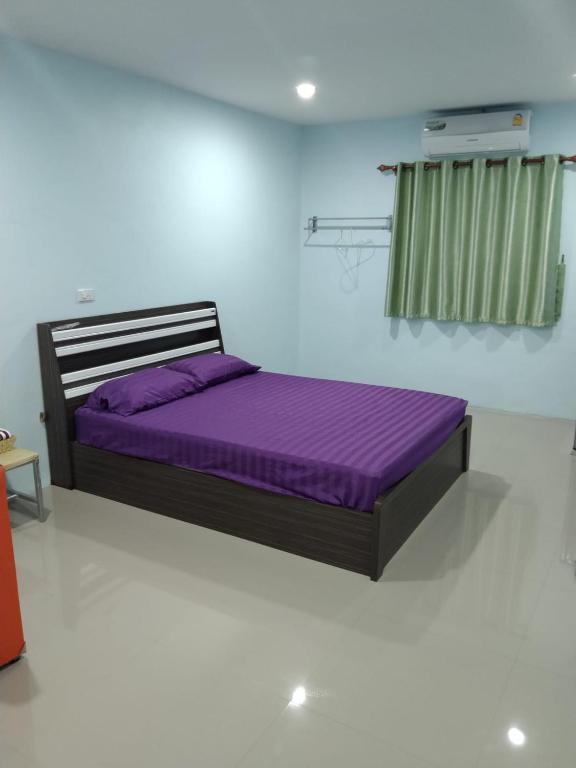 a bed in a room with a purple mattress at OYO 75400 Moo Yim Resort in Rayong