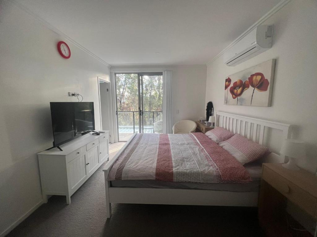 a bedroom with a bed and a tv and a window at Superstar’s home stay in Gold Coast