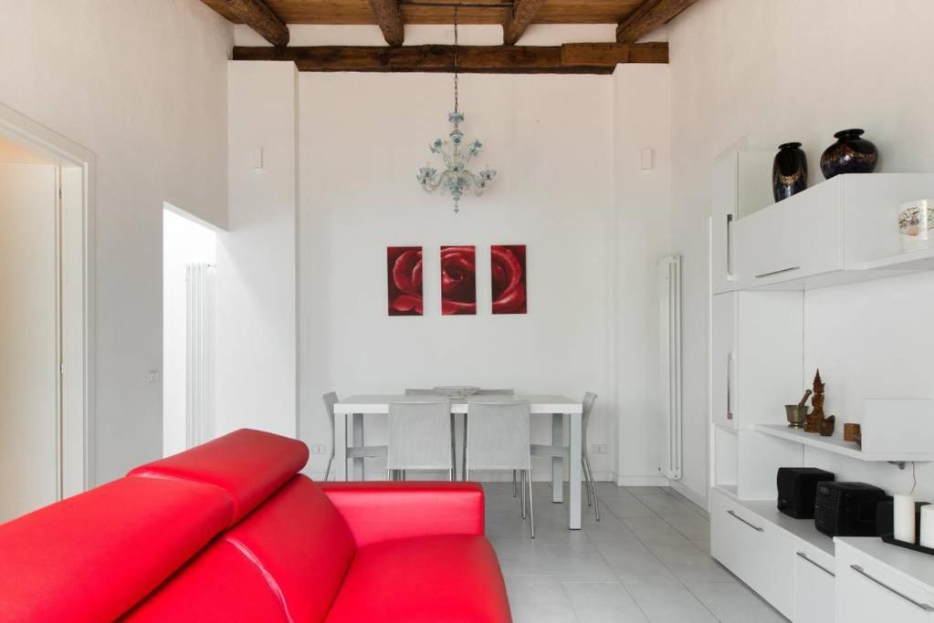a living room with a red couch and a table at CA' DEL CORDER - A secret corner of peace in Venice