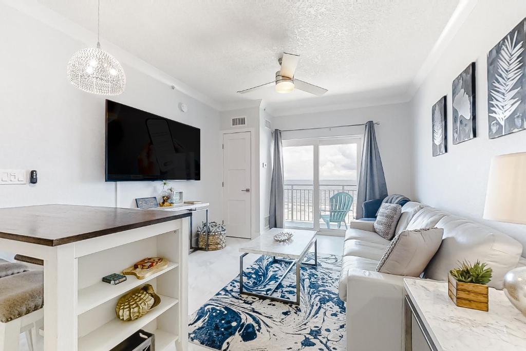 a living room with a white couch and a tv at Coconut Palms Beach Resort II 4512 in New Smyrna Beach