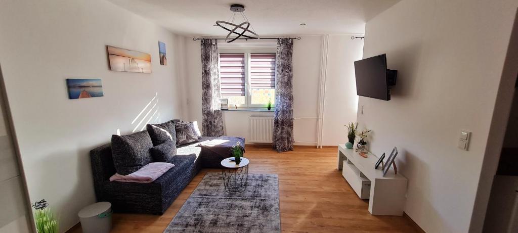 a living room with a couch and a tv at Moderne Wohlfühlferienwohnung in Hildburghausen in Hildburghausen