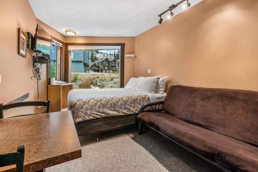 a hotel room with a bed and a couch at Cozy Corner - Whitefoot Lodge 126 in Big White