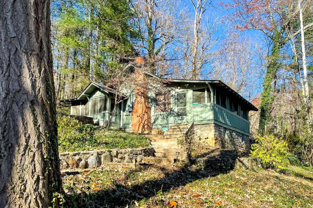 a house sitting on a hill in the woods at Charlotte's Cabin in Waynesville