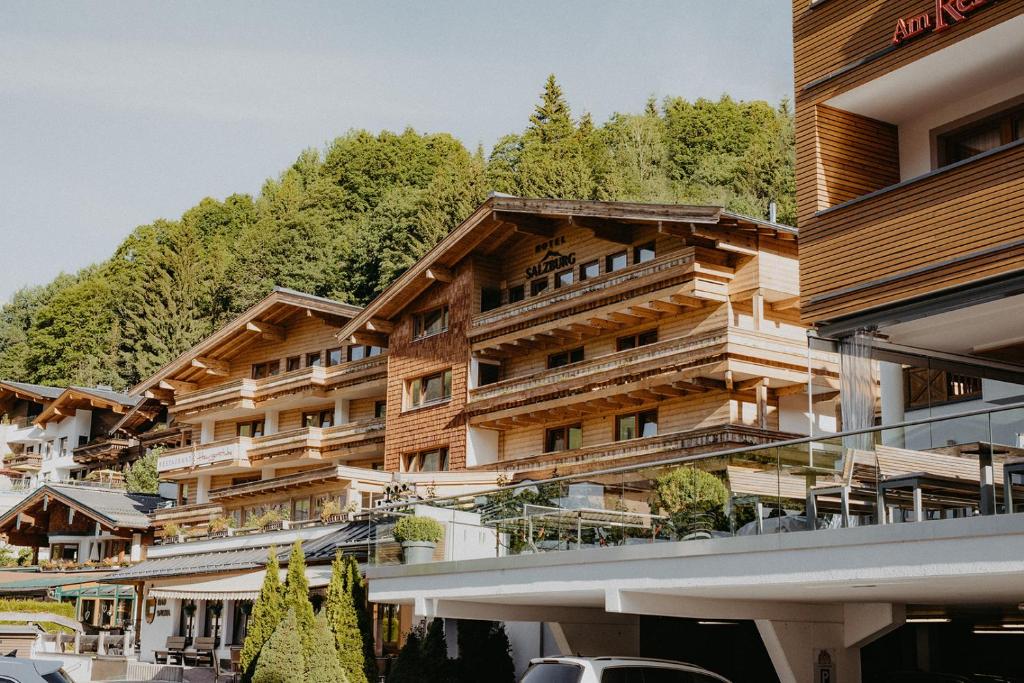 ein großes Holzgebäude mit einem Berg im Hintergrund in der Unterkunft Hotel Salzburg in Saalbach-Hinterglemm