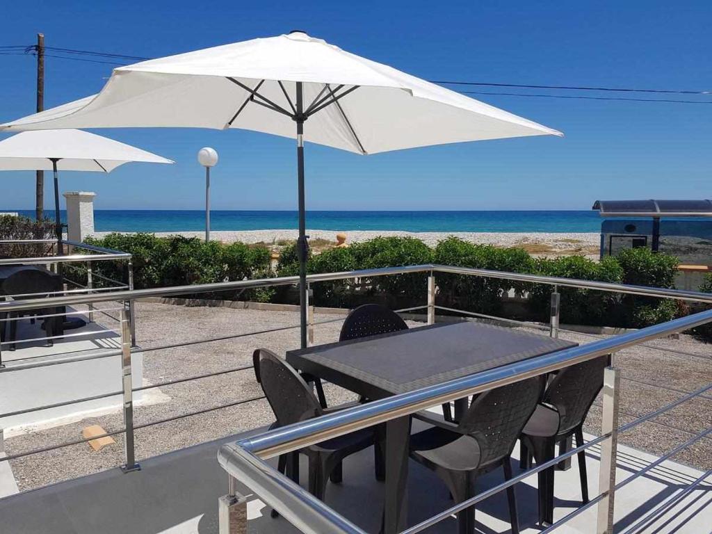 einen Tisch und Stühle mit Sonnenschirm am Strand in der Unterkunft Apartamentos Cap y Corp in Alcossebre