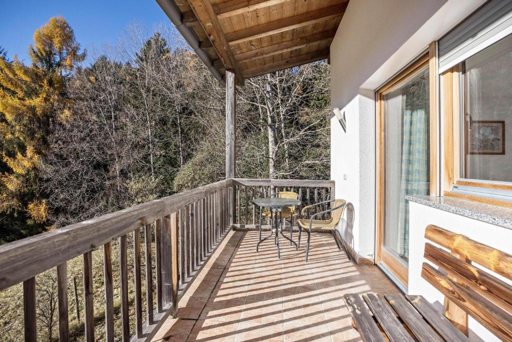 einen Balkon mit einem Tisch und Stühlen darauf in der Unterkunft Bnb Lettnerhof Balcony Family Suite in Welsberg-Taisten