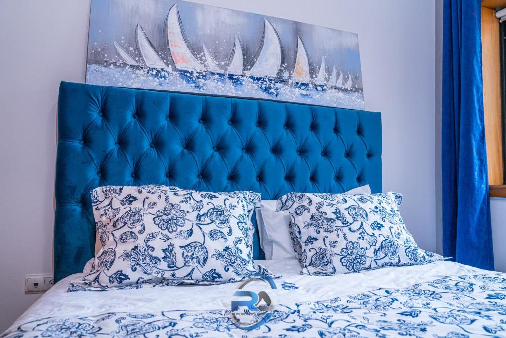a bed with a blue head board and pillows at RAFURADOURO in Ovar