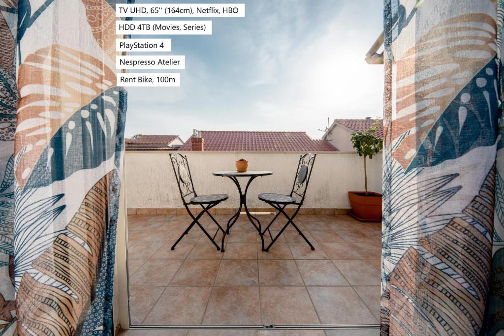 uma vista para uma varanda com uma mesa e cadeiras em Nikolina Rab Apartments em Rab
