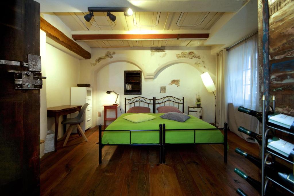 a bedroom with a green bed and a desk at RenaissanceStuben in Torgau