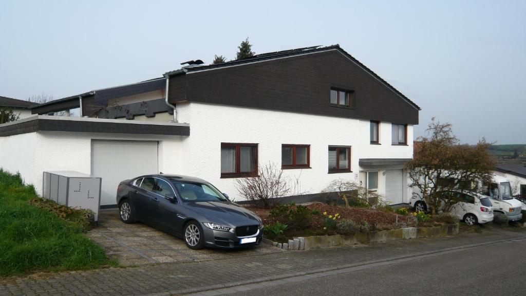 een zwarte auto geparkeerd voor een huis bij Ferienwohnung Sinsheim-Dühren in Sinsheim