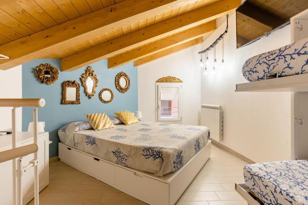 two beds in a bedroom with blue walls and wooden ceilings at La Bella Vita - La Casetta in Chioggia