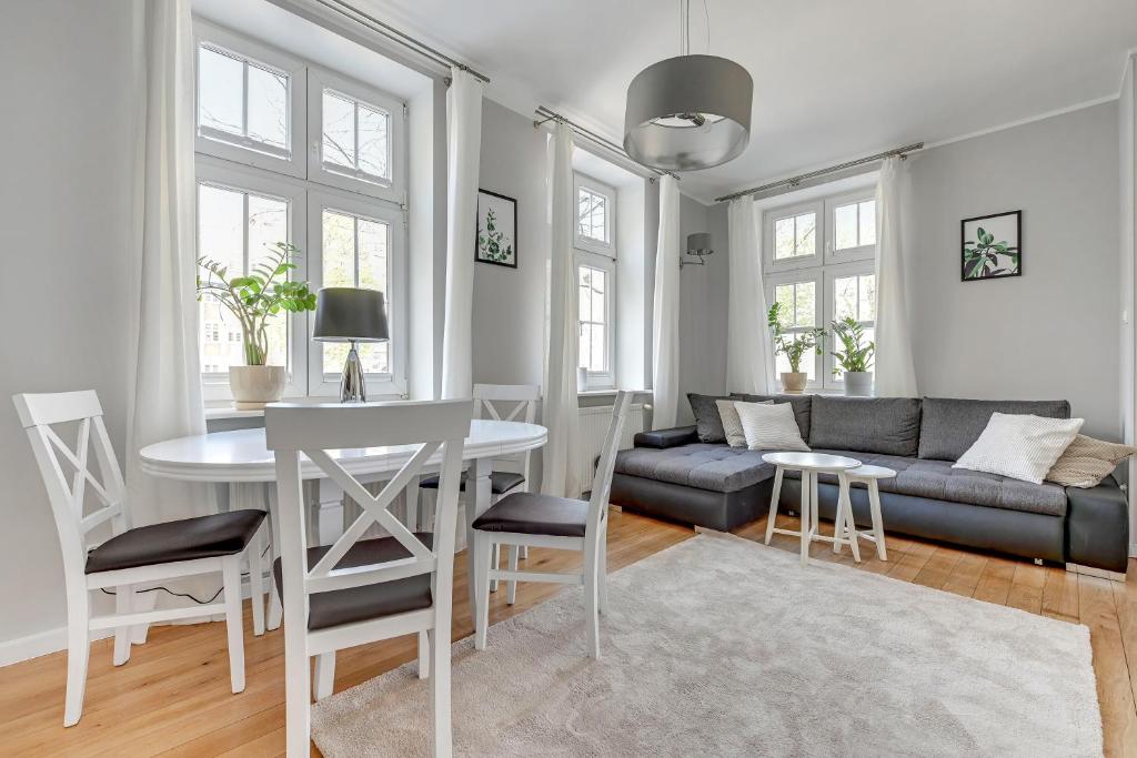 een woonkamer met een tafel en een bank bij Comfort Apartments Old Town Chlebnicka in Gdańsk