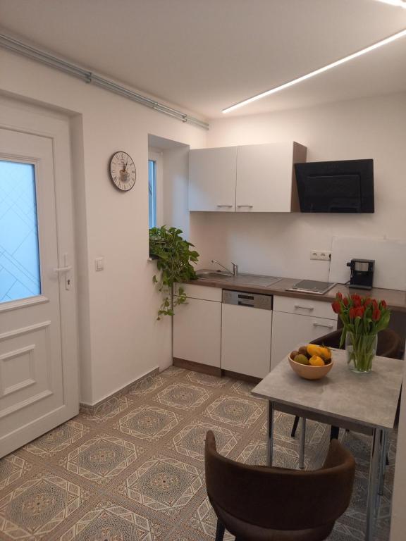 a kitchen with a table with a bowl of fruit on it at Holiday Oasis Appartements in Villach