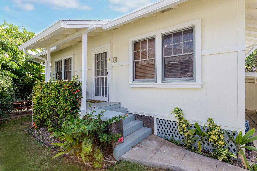 uma casa branca com escadas e uma janela em Garden Cottage Unit A em Honolulu
