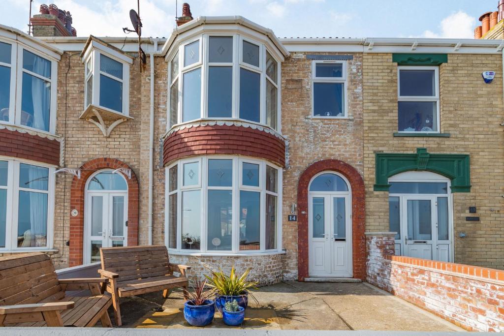 a brick house with a bench and a table at 14 The Promenade in Withernsea