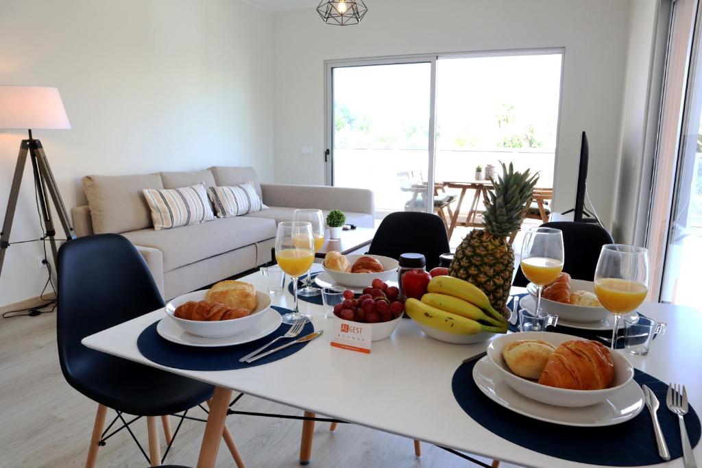 uma mesa com comida e fruta na sala de estar em All Premium by ALgest em Portimão