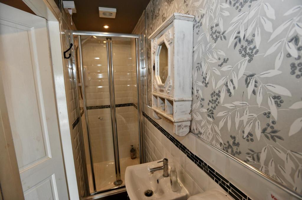 a bathroom with a shower and a sink at Sea View Guest House in Benllech