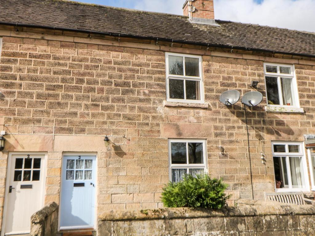 ein altes Backsteinhaus mit weißen Türen und Fenstern in der Unterkunft 3 Castle Orchard in Belper