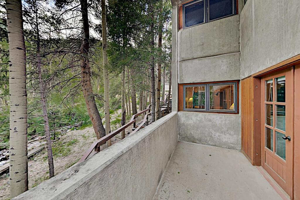 eine Veranda eines Hauses mit einem Fenster und Bäumen in der Unterkunft Predock 1A in Taos Ski Valley