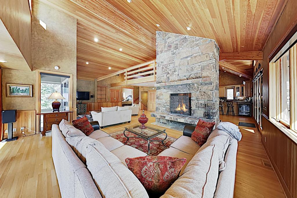 a living room with a couch and a stone fireplace at Golden Eagle Dreams in Park City