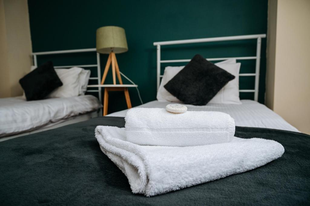 a pile of towels sitting on top of a bed at Highfield Lodge in Sheffield