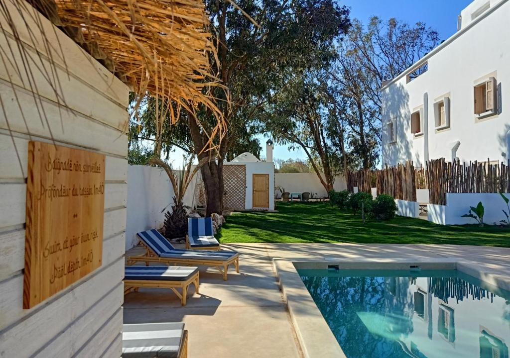 un patio trasero con piscina y una casa en Villa Nour, en Essaouira