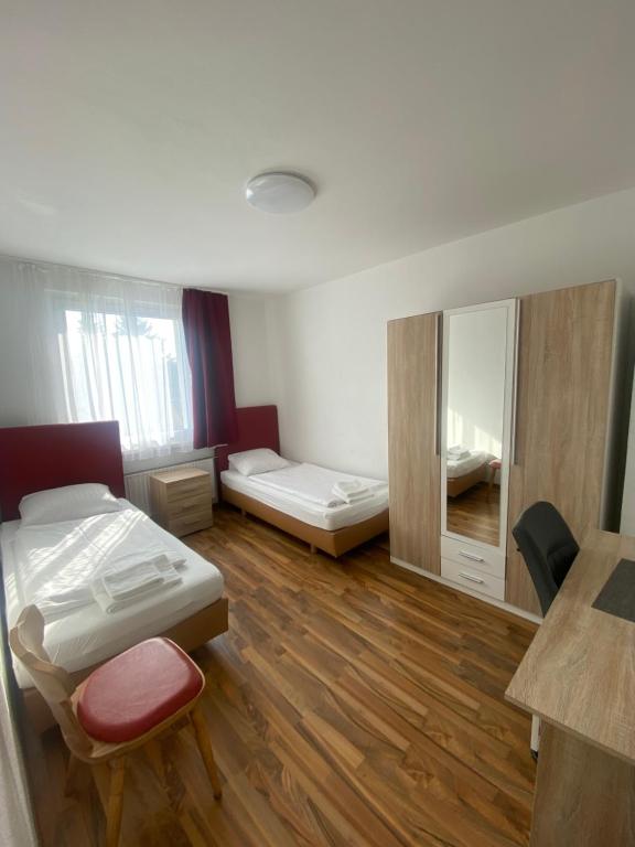 een kamer met 2 bedden en een spiegel bij Othman Appartements Hannoversche Straße 23 in Hannover