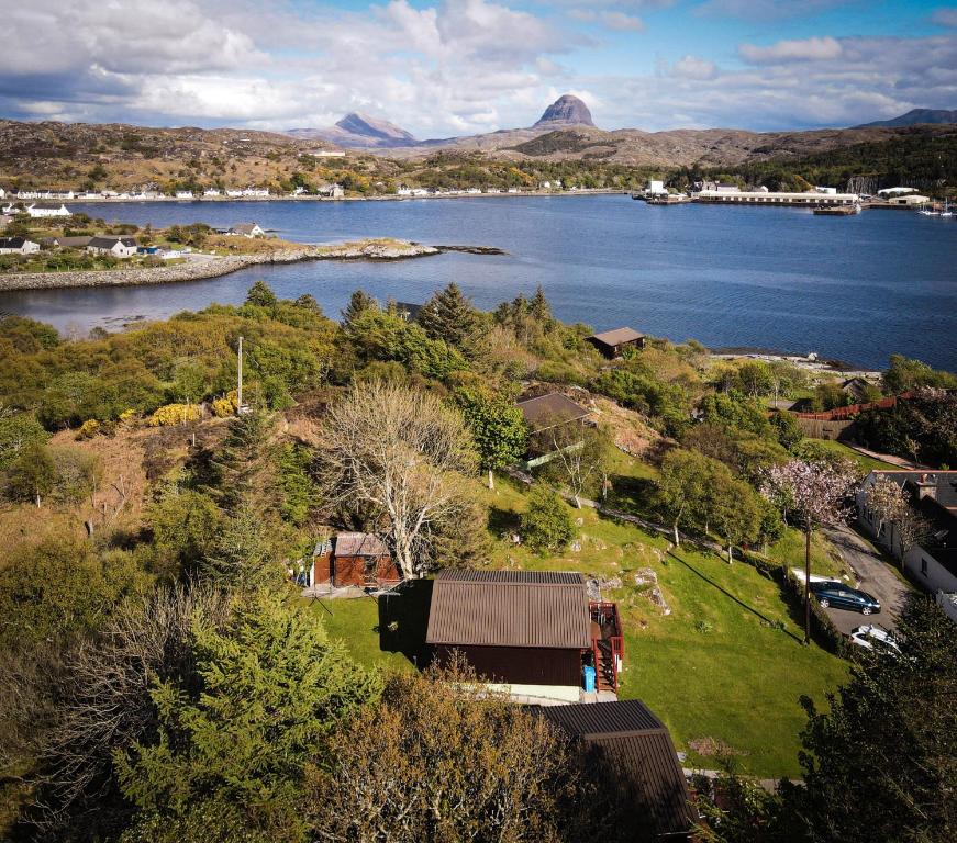 an aerial view of a town and a lake at Caisteal Liath in Lochinver