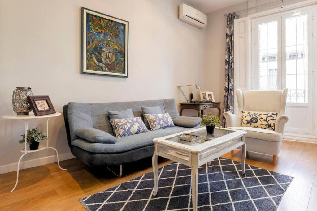 uma sala de estar com um sofá azul e uma mesa em Minty Stay - Montera em Madri