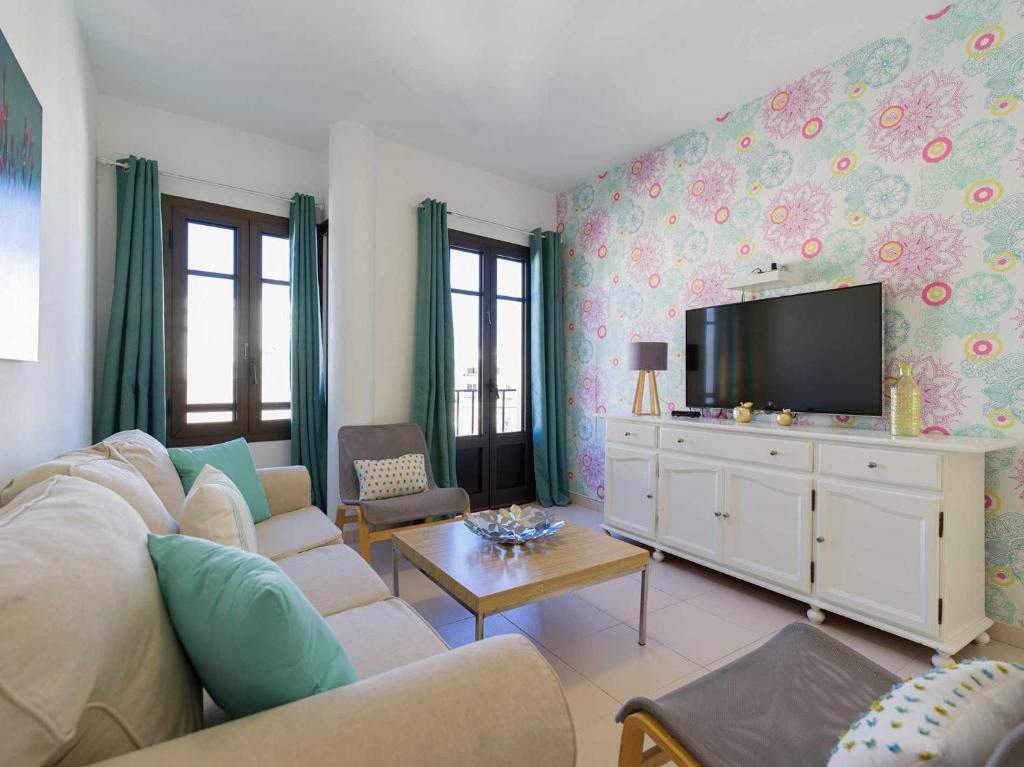 Mahostly Apartamento Comillas SC في أريثيفي: غرفة معيشة مع أريكة وتلفزيون بشاشة مسطحة