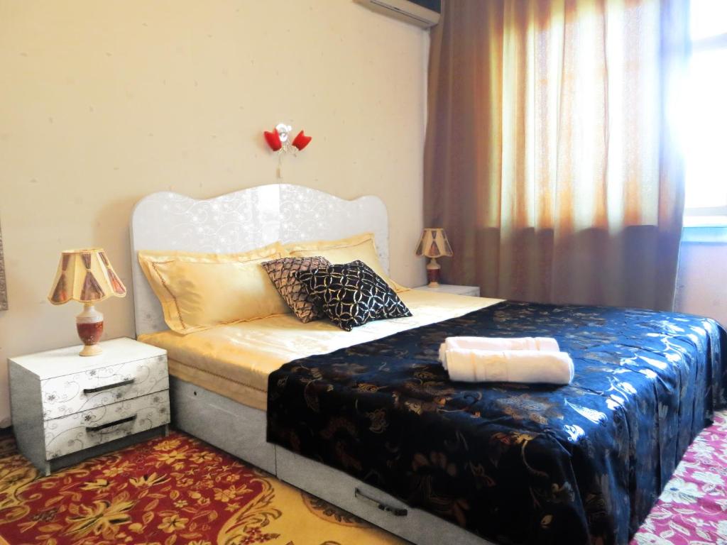 - une chambre dotée d'un lit avec un cadre blanc dans l'établissement Bishkek City Apartments, à Bishkek