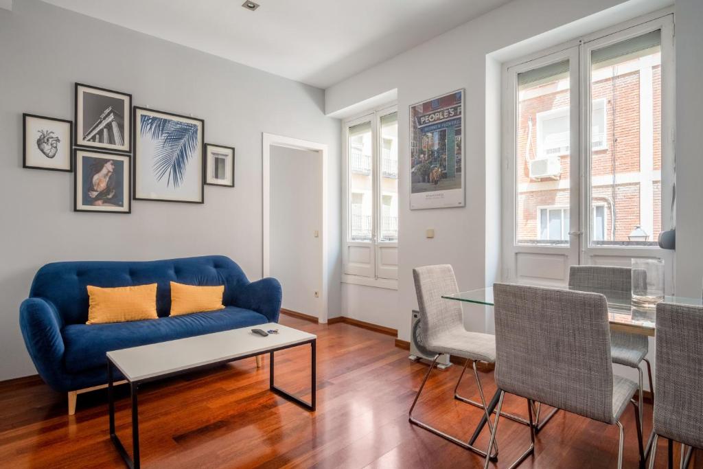 a living room with a blue couch and a table at 2 bedrooms 1 bathroom furnished - Anton Martin - Vintage - MintyStay in Madrid