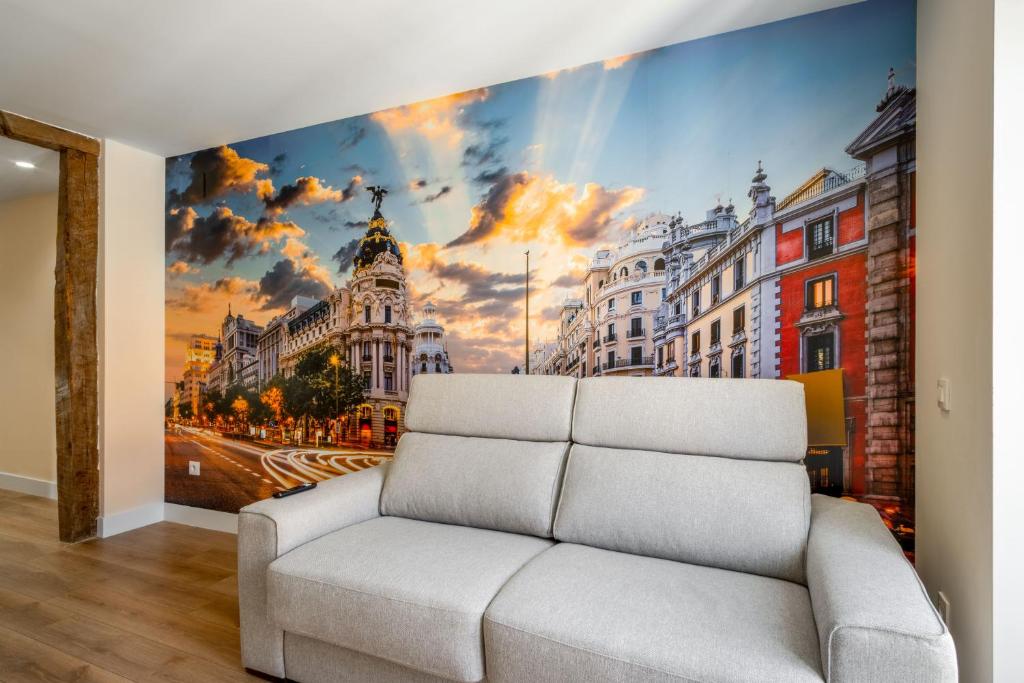 un sofá blanco en una habitación con un mural de la ciudad en 2 bedrooms 2 bathrooms furnished - Malasaña - bright and refurbished - MintyStay en Madrid