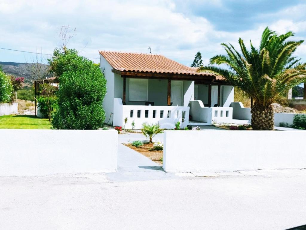 a house with a white fence in front of it at V&E's Apartments in Pigádhia