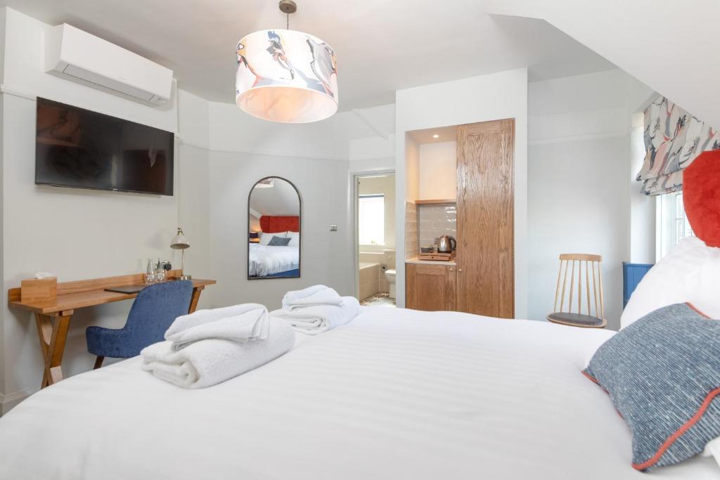 a bedroom with a large white bed and a desk at The Chequers Inn in Knebworth