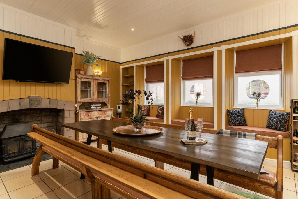 a living room with a wooden table and a fireplace at 50TheHighstreet by The House of Danu in Kingussie