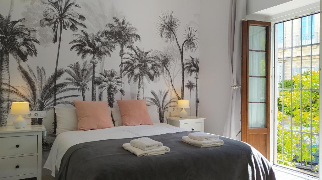 1 dormitorio con 1 cama con palmeras en la pared en Sherryflat San Agustín en Jerez de la Frontera