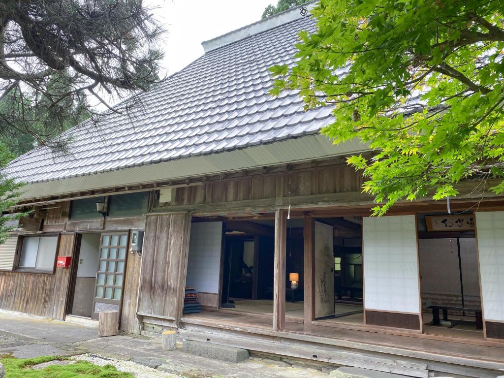 un vieux bâtiment avec un toit rayé dans l'établissement くつき鯖街道 古民家cocco小入谷, à Takashima