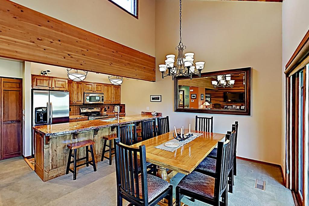 a dining room with a wooden table and a kitchen at Lakeside Adventure in Park City