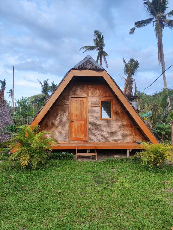 a thatch roofed house with a wooden door at Acuario Beach Inn in San Vicente