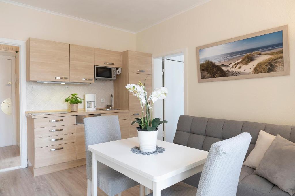 ein Wohnzimmer mit einem weißen Tisch und einem Sofa in der Unterkunft Solymar Strandgeschichten in Grömitz