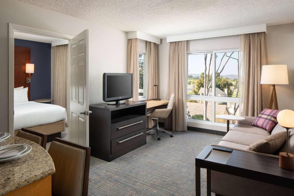 a hotel room with a bed and a desk with a television at Sonesta ES Suites Carmel Mountain - San Diego in San Diego