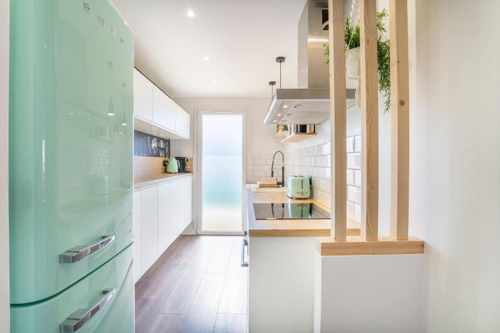 a kitchen with white cabinets and a blue refrigerator at L'APP'ART -MODERNE & COSY -Pradet Centre & Proche des Plages in Le Pradet