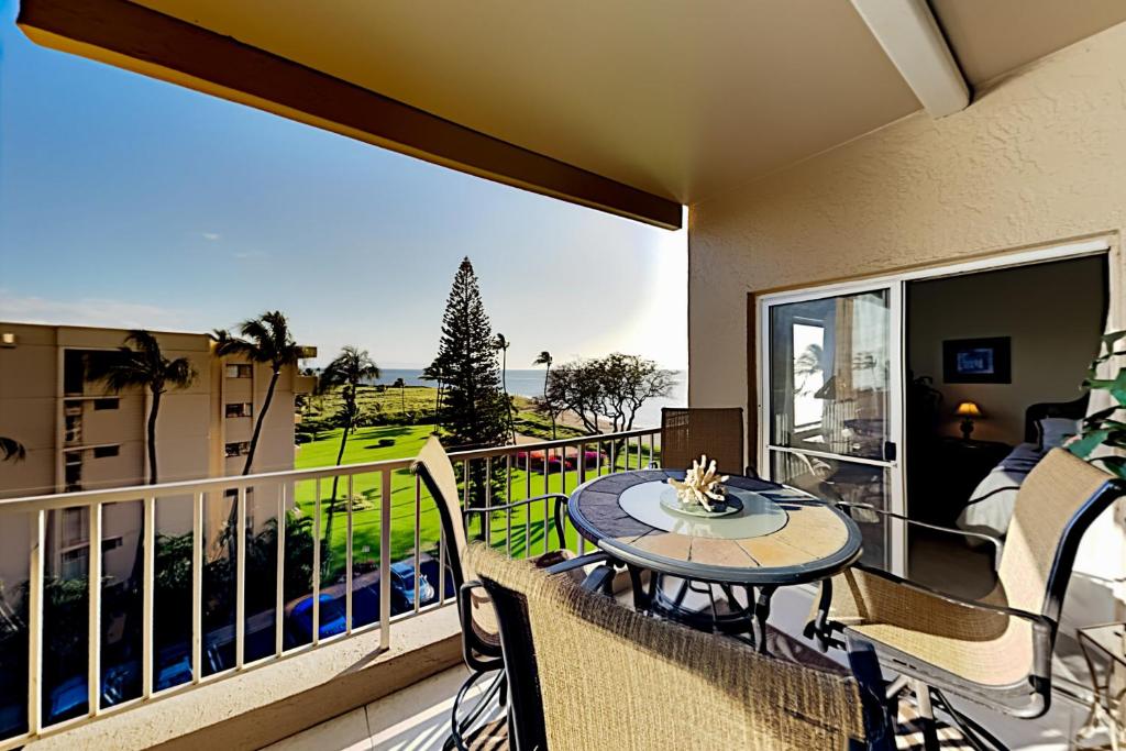 a balcony with a table and chairs on a balcony at Menehune Shores 626 in Kihei