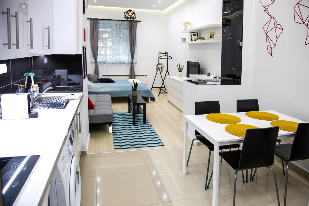 cocina y sala de estar con mesa y sillas en OAZU downtown flat, en Budapest