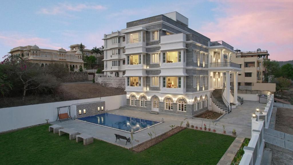 a large white mansion with a swimming pool at Boheda Manor - Luxury Retreat in Udaipur