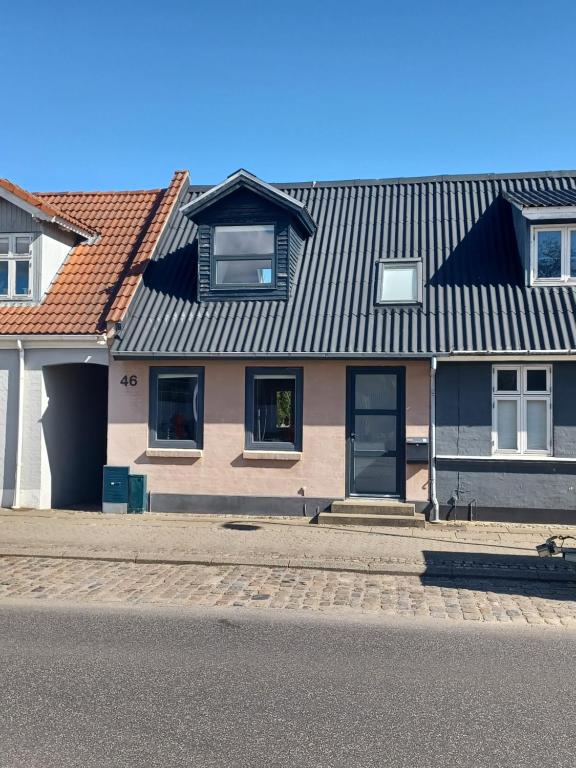 ein Haus mit einem Blechdach auf einer Straße in der Unterkunft "City Sleep" in Nykøbing Mors